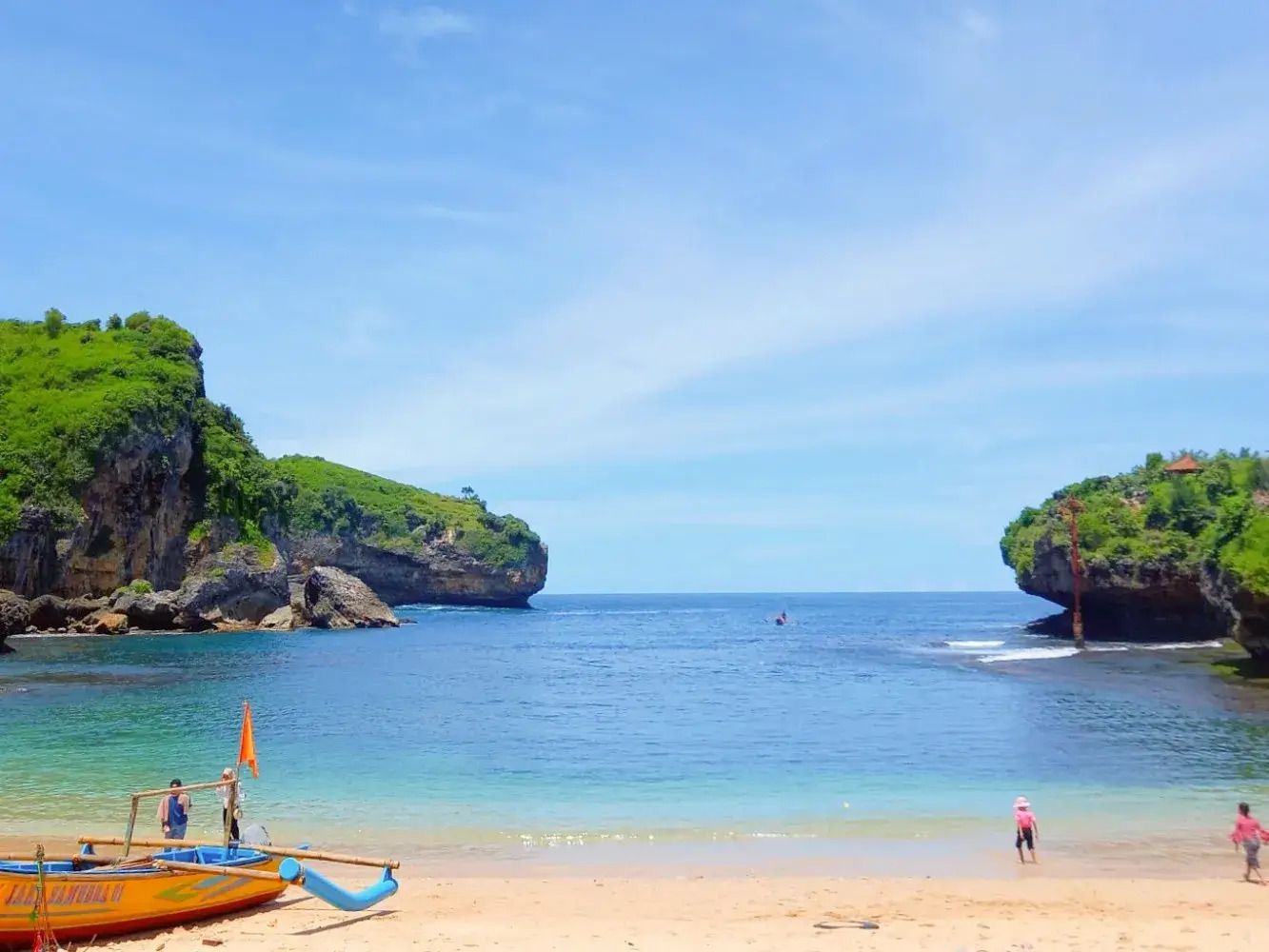 Pantai Gesing Jogja dengan pasir putih dan perahu nelayan, Keindahan Pantai Gesing Gunung Kidul saat matahari terbenam, Spot foto Bukit Batu Karang Pantai Gesing Yogyakarta, Wisatawan menikmati suasana Pantai Gesing Jogja